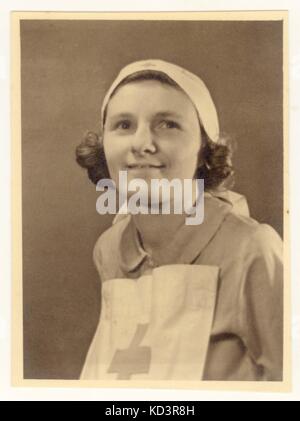 Portrait photograph of a caring young Red Cross nurse wearing a Voluntary Aid Detachment (VAD) uniform circa 1940, U.K. Stock Photo