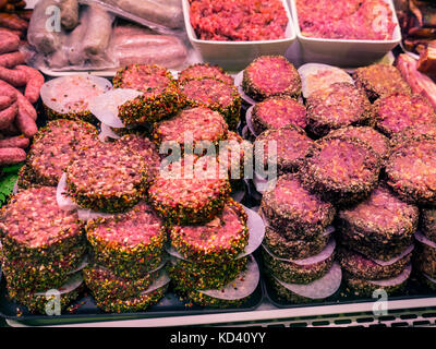 CONCEPT MEAT CONSUMPTION Raw Beef hamburgers, mince & sausages on display for sale in butchers chilled cabinet Quimper Brittany France Stock Photo
