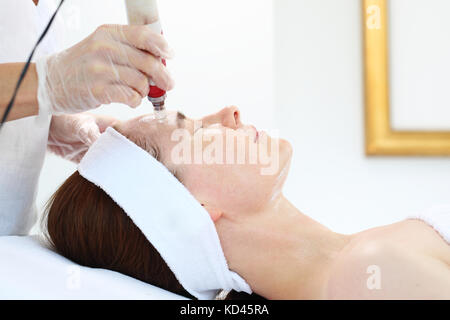 Mesotherapy microneedle, the woman at the beautician. Beautician performs a needle mesotherapy treatment on a woman's face Stock Photo