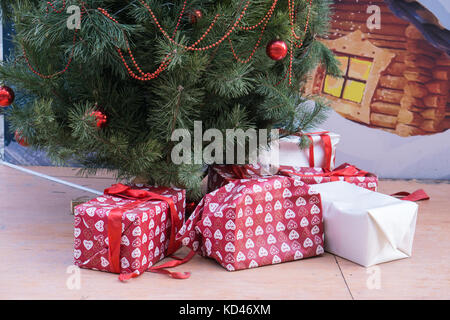 many different gift box presents under new year tree some of them unwrapped. christmas aftermath Stock Photo
