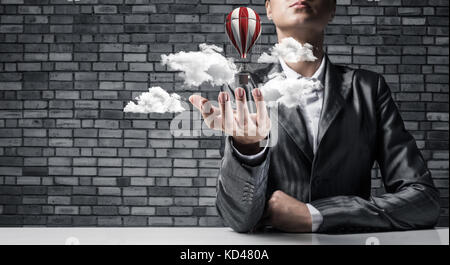 Woman presenting flying balloon in hand. Stock Photo