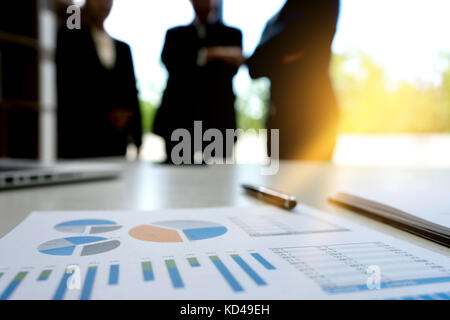 Businesswoman and Businessman stand in out of focus graph chart on the table concept business consult Stock Photo