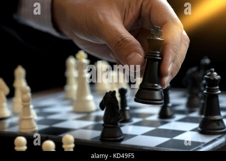 Businessman play chess use King - Chess Piece white to crash overthrow the competitor concept business strategy for win Stock Photo