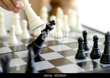 Businessman play chess use King - Chess Piece white to crash overthrow the competitor concept business strategy for win Stock Photo