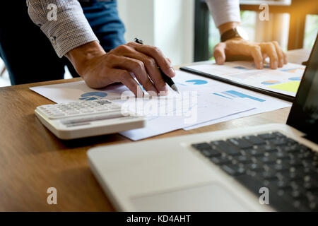 Businessman standing work on wood table prepare and read graph and paper marketing plan concept freelance startup business Stock Photo