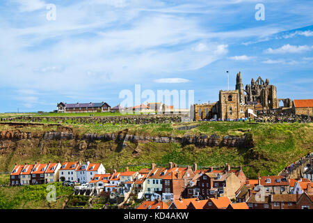 View of Church and Abbey ruins on top of cliffs above Whitby Town Stock Photo
