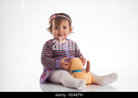 Beautiful little baby girl playing with dog toy, portrait Stock Photo