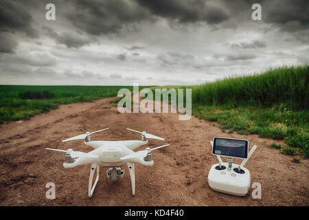 Remote control and drone on a green wheat field Stock Photo