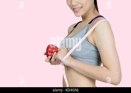 slim woman smile body with apple fruit isolated on pink background with clipping path Stock Photo