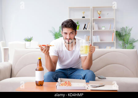 Man eating pizza having a takeaway at home relaxing resting Stock Photo