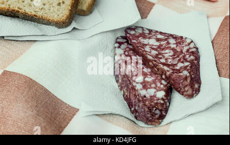 Tablecloths on napkins are two delicious piece of sausage and two pieces of bread. Stock Photo