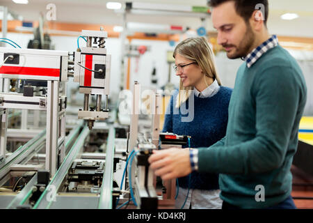 Two young handsome engineers working on electronics components Stock Photo