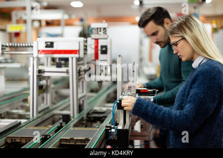 Two young handsome engineers working on electronics components Stock Photo