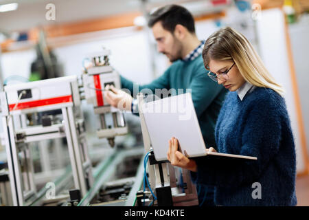 Two young handsome engineers working on electronics components Stock Photo