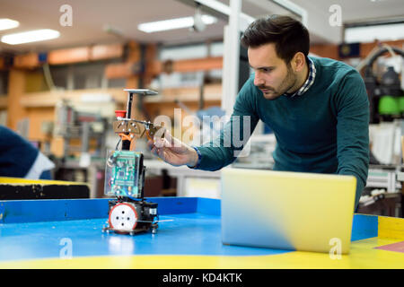Young engineer testing his robot in workshop Stock Photo