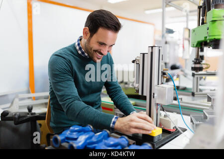 Two young handsome engineers working on electronics components Stock Photo