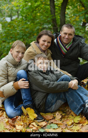 Happy smiling family sitting on leaves