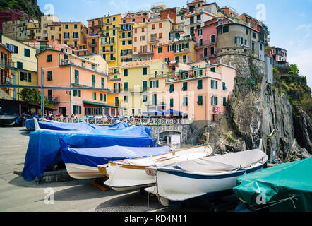 The small fishermen village of Manarola, with its fishing boats and colorful houses hanging to the cliff, is one of the five town of the Cinque Terre  Stock Photo