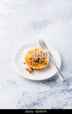Thanksgiving day concept with homemade pumpkin tartlet, mini pie, on gray stone background. Healthy autumn food, copy space. Stock Photo
