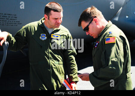 U.S. Air Force Capt. Chris Langley and Lt. Col. Lamar Thigpen, deployed Air Force Ground Commander for the 315th Airlift Control Flight, brief one another prior to departing Wright Army Airfield (WAAF). The South Carolina Army National Guard’s 1-118th Combined Arms Battalion (CAB) participates in heavy airlift operations April 10-11, 2014 at Wright Army Airfield (WAAF), Hinesville, Ga., to demonstrate the joint, total force, capabilities of the S.C. Army Guard and U.S. Air Force Reserve’s 315th Airlift Wing.  Soldiers and Airmen worked in unison over two days to load and secure four of the 1-1 Stock Photo