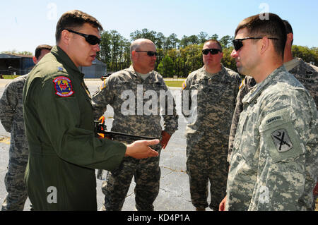 U.S. Air Force Lt. Col. Lamar Thigpen, Deployed Ground Commander for the 31th Airlift Control Flight, briefs Capt. Ben Thornton, prior to uploading a M1A1SA onto an awaiting C-17 transport plane. The South Carolina Army National Guard’s 1-118th Combined Arms Battalion (CAB) participates in heavy airlift operations April 10-11, 2014 at Wright Army Airfield (WAAF), Hinesville, Ga., to demonstrate the joint, total force, capabilities of the S.C. Army Guard and U.S. Air Force Reserve’s 315th Airlift Wing.  Soldiers and Airmen worked in unison over two days to load and secure four of the 1-118th CA Stock Photo