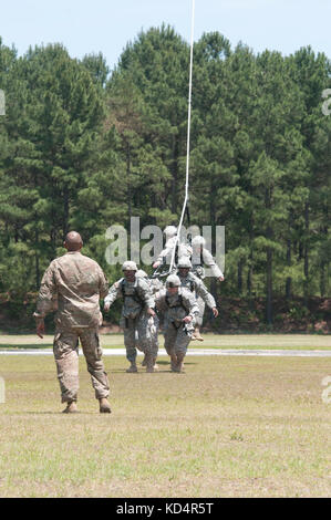 A U.S. Army Soldier assigned to 7th Special Forces Group (Airborne) guides a group of South Carolina Army National Guard Soldiers assigned to 4th Battalion, 118th Infantry Regiment, during Special Insertion Exfiltration System (SPIES) training at McCrady Training Center, Eastover, S.C., May 17, 2014.  The Soldiers landed safely to the ground by a Chinook provided by the 160th Special Operations Aviation Regiment (Airborne). (U.S. Army National Guard photo by Sgt. 1st Class Kimberly D. Calkins/Released) Stock Photo