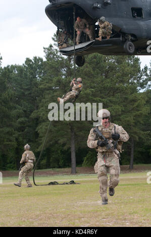 Three Airmen assigned to the 22nd Special Tactics Squadron, Joint Base Lewis-McCord, Wash., complete Fast Rope Insertion Exfiltration System training at McCrady Training Center, Eastover, S.C., May 17, 2014. The FRIES training was just one part of a five-day training exercise held in cooperation between 4th Battalion, 118th Infantry Regiment, 218th Maneuver Enhancement Brigade; the 160th Special Operations Aviation Regiment (Airborne) and the 7th Special Forces Group (Airborne). (U.S. Army National Guard photo by Sgt. 1st Class Kimberly D. Calkins/Released) Stock Photo