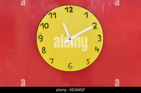 Wooden big yellow clock in children playground. Time abstraction. Stock Photo