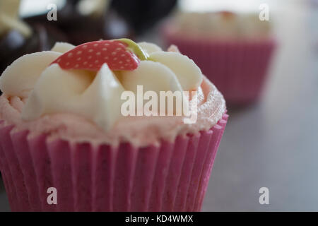 Strawberry and Chocolate Cupcakes Accompanied by Hot Chocolate with Cream and Chocolate dusting. Stock Photo