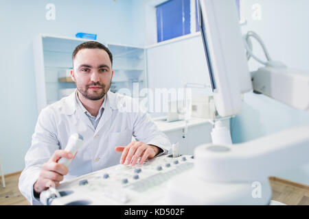 handsome doctor using an ultrasound machine Stock Photo