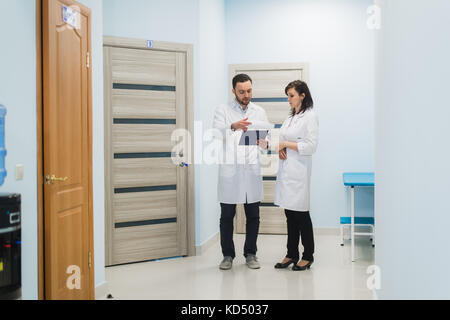 Two doctors discussing diagnosis while walking Stock Photo