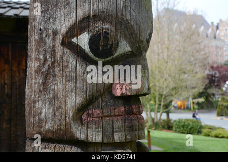 A depiction of a human face on an old Northwest Coast indigenous totem pole, in Victoria, British Columbia, Canada. Stock Photo