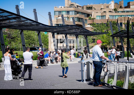 People walking along the Georgetown Waterfront Park, a recently completed national park on the Potomac River in Washington DC. Summer family activity Stock Photo