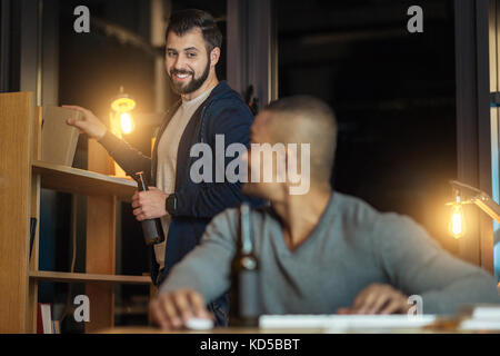 Smiling bearded man holding interesting book Stock Photo
