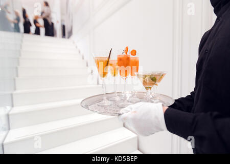 Crop waiter with drinks on tray on a white background Stock Photo