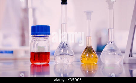 Laboratory flasks and beakers with liquids of different colors on lab table Stock Photo