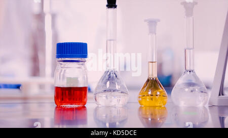 Laboratory flasks and beakers with liquids of different colors on lab table Stock Photo