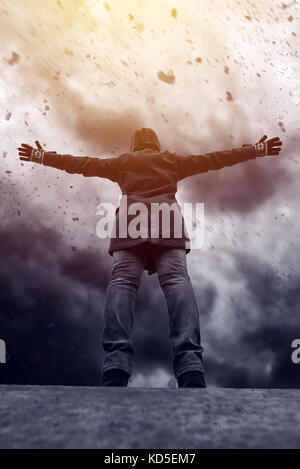 Unrecognizable hooded female person facing concrete wall as ...