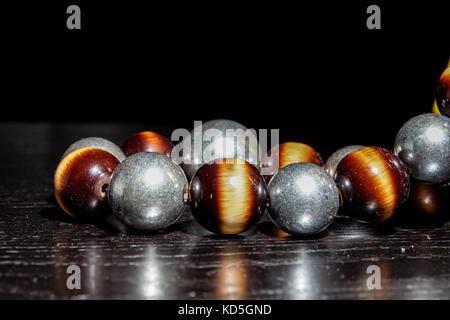ound colored stone necklace on black table and background. selective focus Stock Photo
