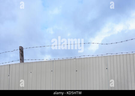 Barbed wire against the blue sky. Stock Photo