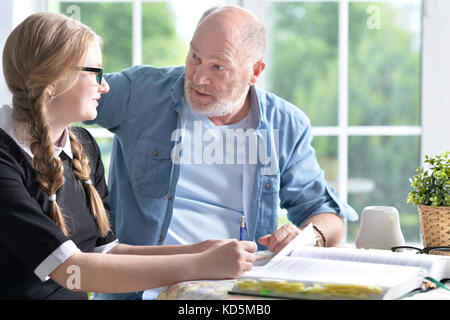 Grandfather and granddaughter doing homework  Stock Photo