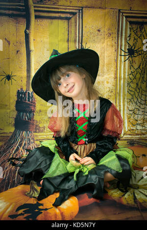 Little Girl wearing Halloween costume. She is five years old and very excited. Images taken over a Halloween background. Stock Photo