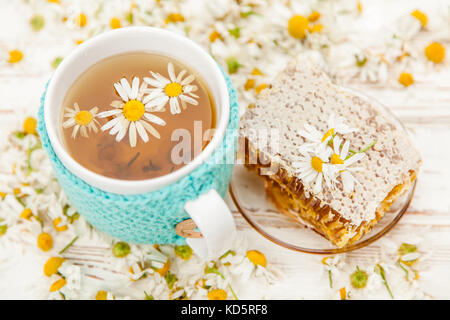 Honeycomb and chamomile tea on white Stock Photo