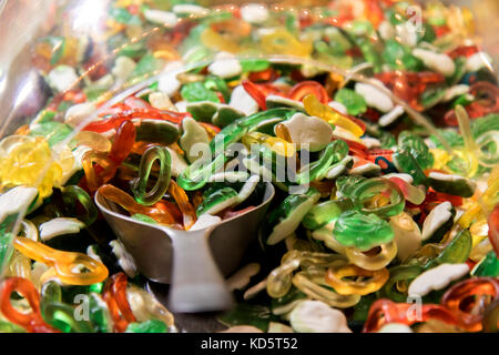 Small scoop in a plastic box with a pile of rubber candy. Offer of jelly sweets in the shop. Stock Photo