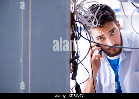 Electrician trying to untangle wires in repair concept Stock Photo