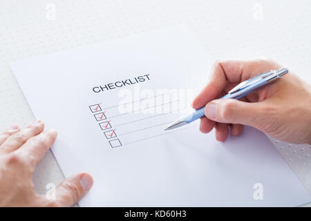 Close-up Of Human Hand Filling Check Boxes On Form Stock Photo
