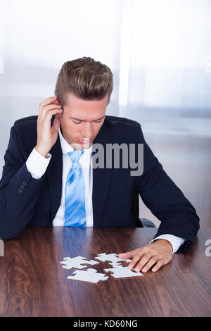 Close-up Photo Of Businessman Connecting Jigsaw Puzzle Stock Photo