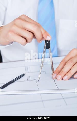 Close-up Of Male Architect Working On Blueprint At Desk Stock Photo