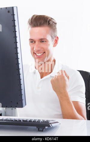 Happy Young Excited Man Using Computer Over White Background Stock Photo