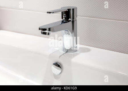 Modern chrome faucet in bathroom Stock Photo